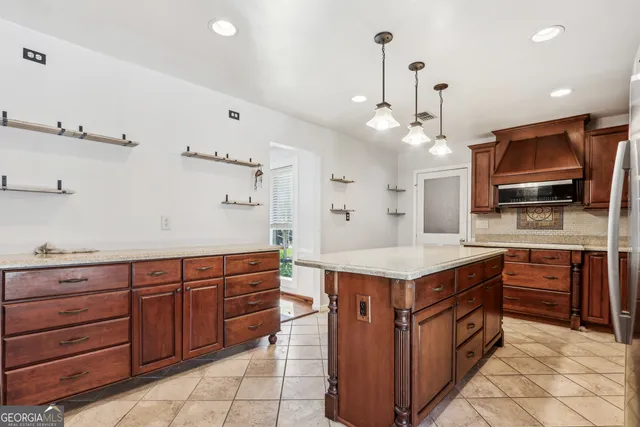 a kitchen with kitchen island a sink stove and refrigerator