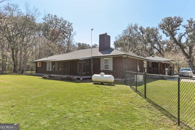 a front view of house with yard and trees in the background