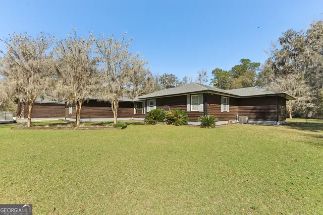 a view of a house with pool and a yard