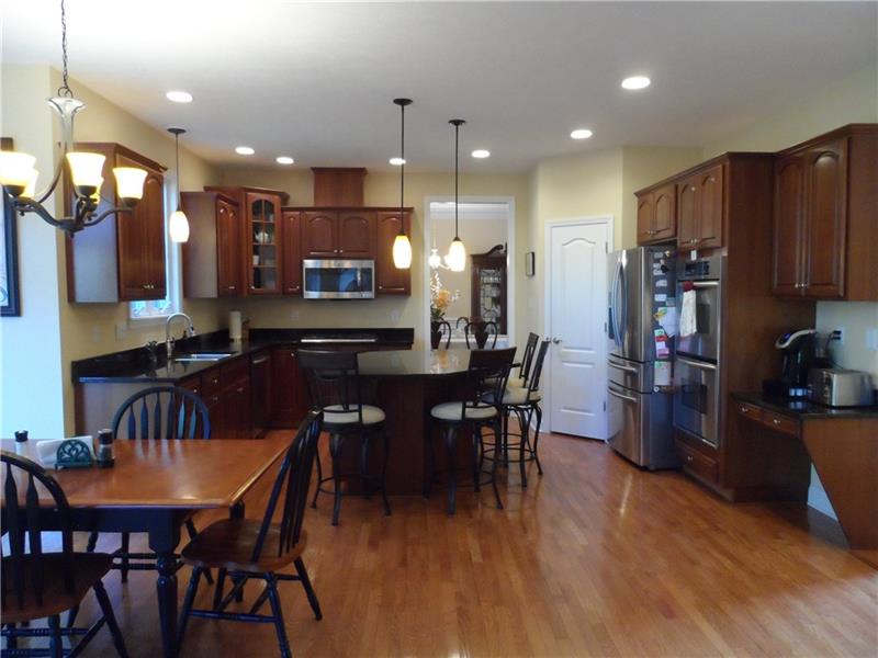 Cherry and granite kitchen, showing hardwood floors with door to rear deck, pantry, large island, secretary and more
