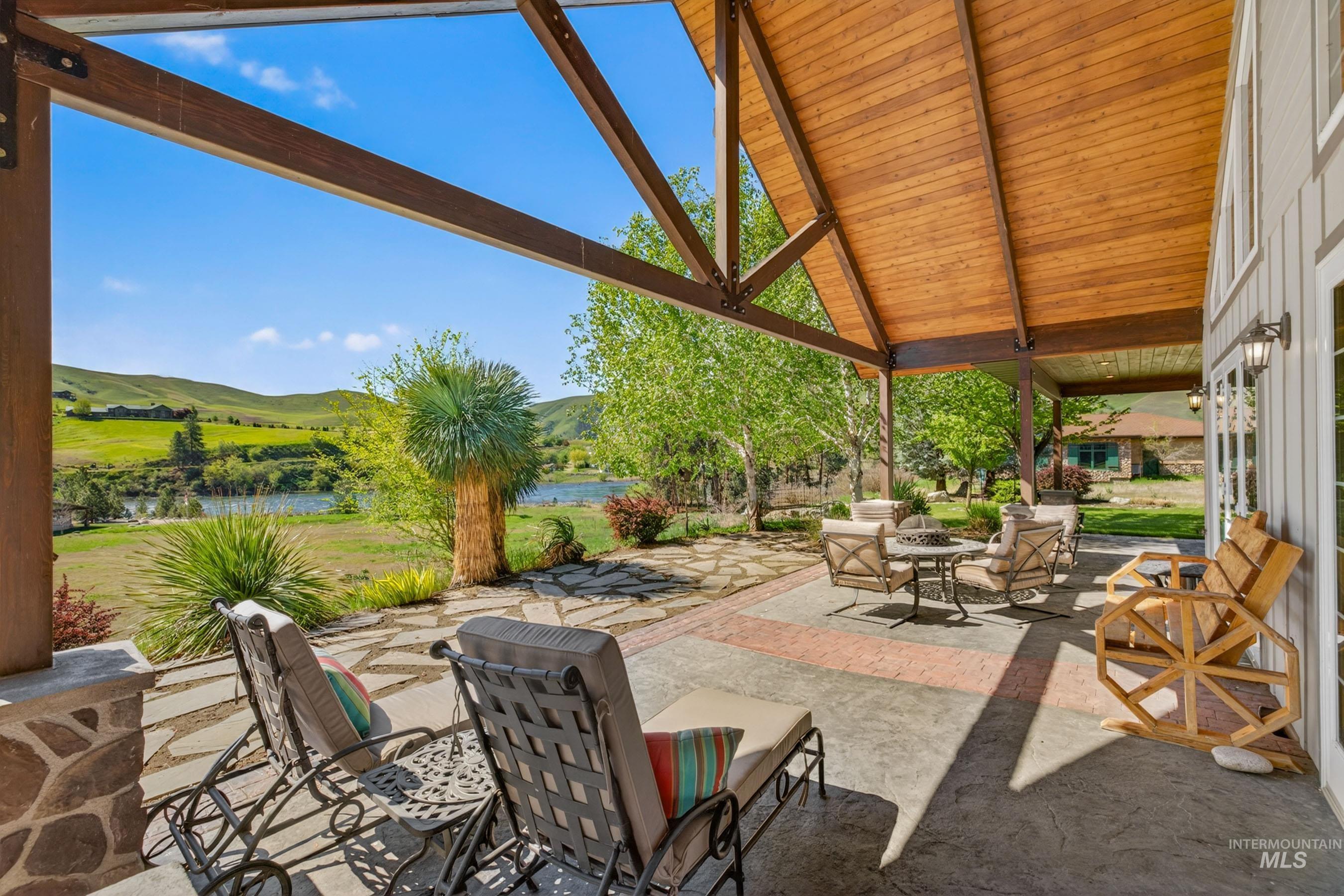 113 Deford Road White Bird, ID 83554 - Photo 31 of 49 Expansive covered patio featuring a vaulted wood-finish ceiling, exposed beams, and a stone-clad pillar