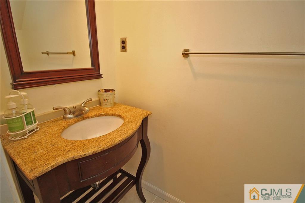 6106 Hana Road Edison, NJ 08817 - Photo 14 of 25 a bathroom with a granite countertop sink and a mirror