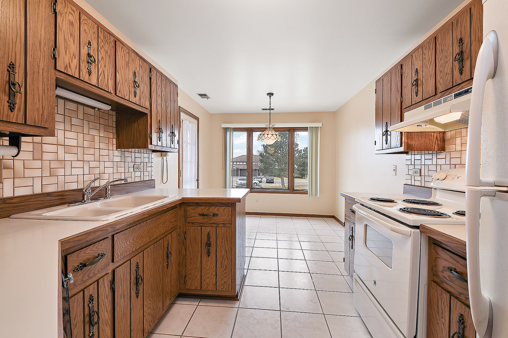 9722 West Creek Road, Unit E2 Palos Park, IL 60464 - Photo 7 of 18 a kitchen with stainless steel appliances a sink stove cabinets and a window