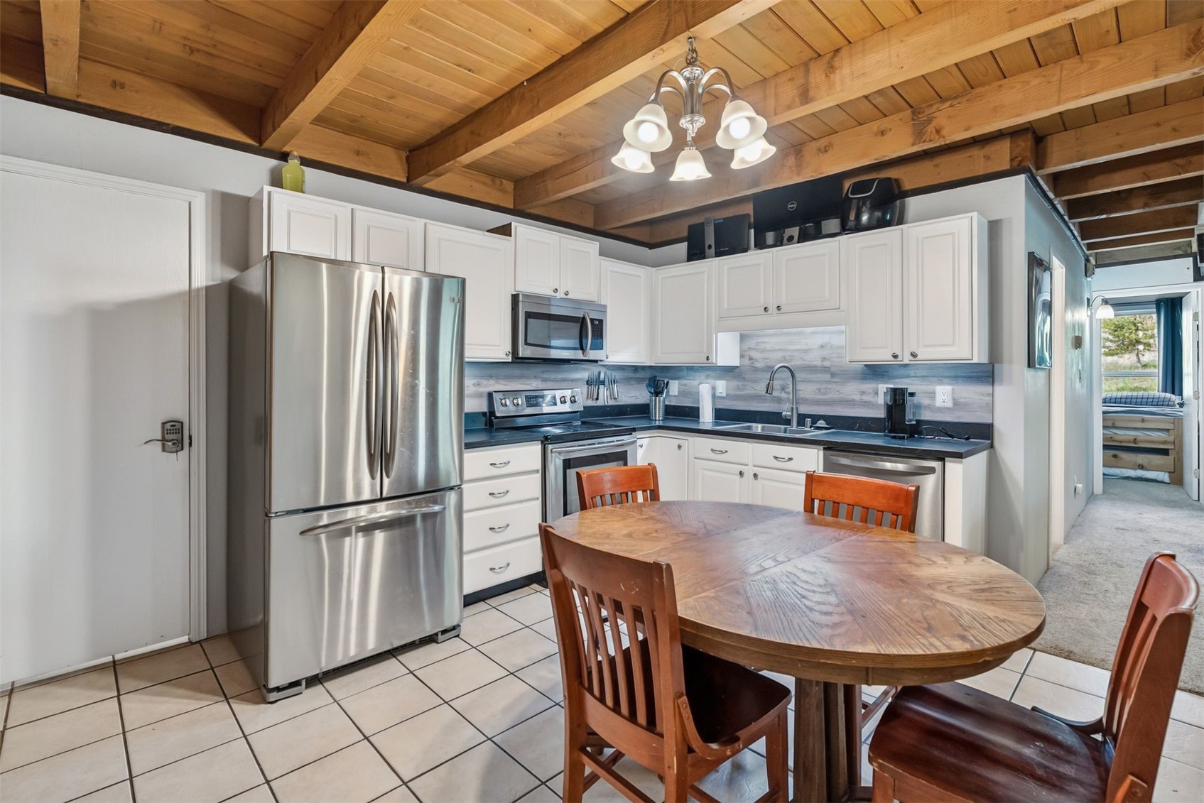 8100 Ryan Gulch Road, Unit 106 Wildernest, CO 80498 - Photo 3 of 43 a kitchen with stainless steel appliances granite countertop a refrigerator a stove a sink a dining table and chairs