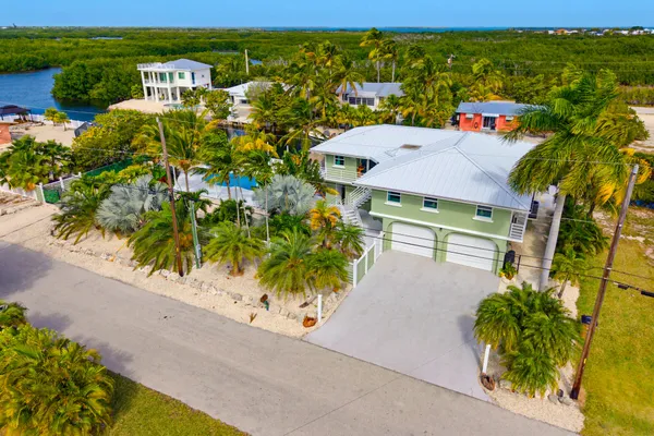 an aerial view of a house with swimming pool and outdoor seating