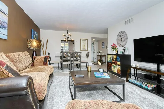 a living room with furniture a flat screen tv and a floor to ceiling window