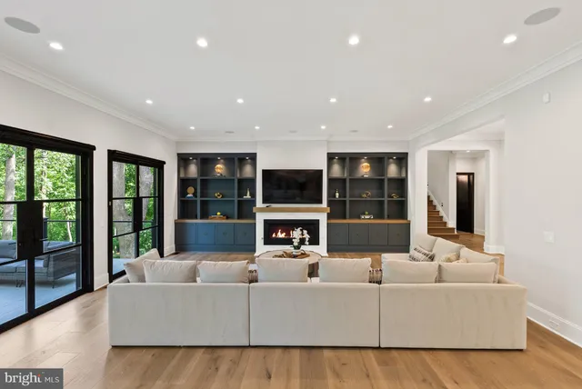 a living room with fireplace furniture and a large window