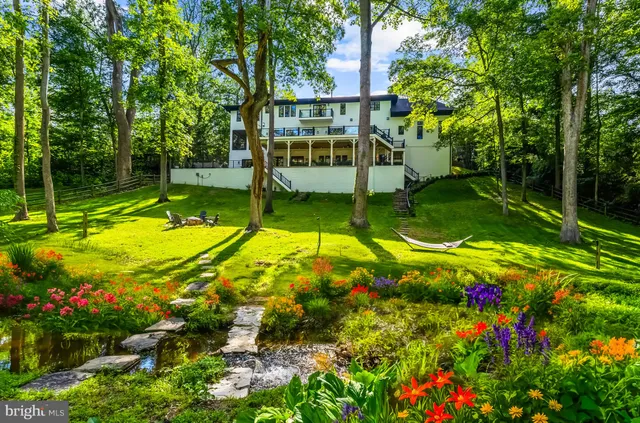 an aerial view of residential house with outdoor space and trees all around