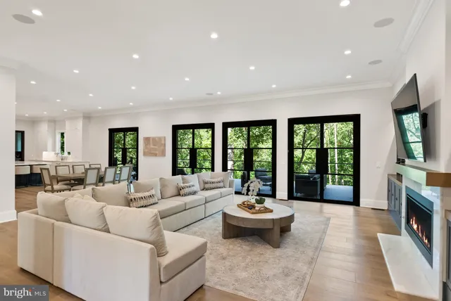 a living room with fireplace furniture and a large window
