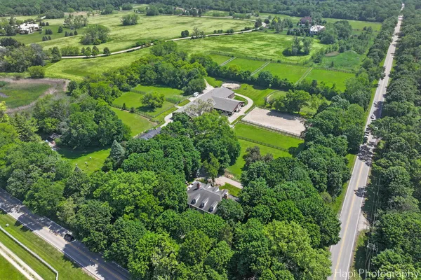 an aerial view of residential house with outdoor space and trees all around