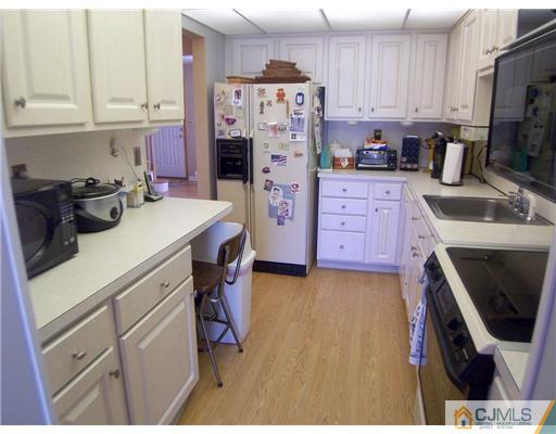 173 Midfield Road Colonia, NJ 07067 - Photo 7 of 25 a kitchen with a refrigerator a stove a sink a washer dryer and cabinets