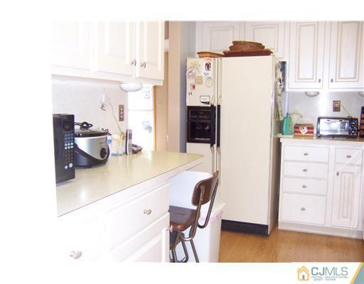 173 Midfield Road Colonia, NJ 07067 - Photo 9 of 25 a kitchen with refrigerator and cabinets