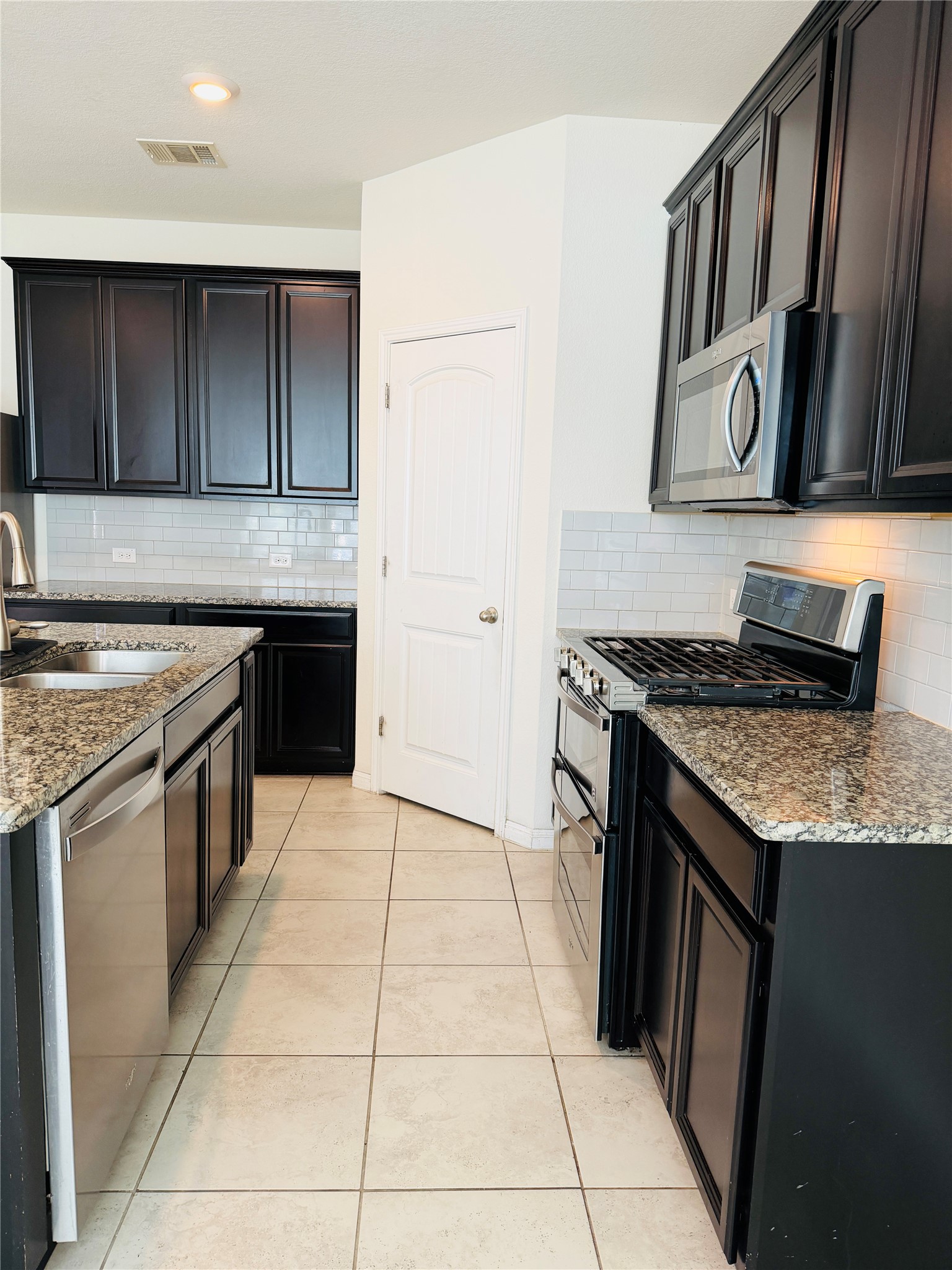 2013 Hat Bender Loop Round Rock, TX 78664 - Photo 5 of 16 Kitchen featuring stainless steel appliances, light stone counters, and backsplash