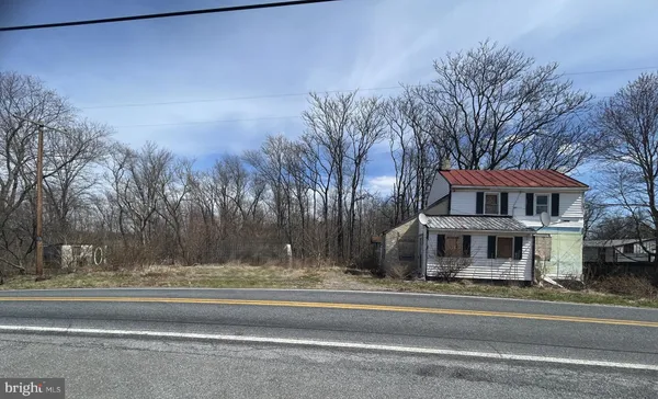 a front view of a house with a yard and parking spaces
