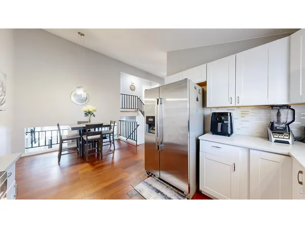 a kitchen with stainless steel appliances a dining table and chairs