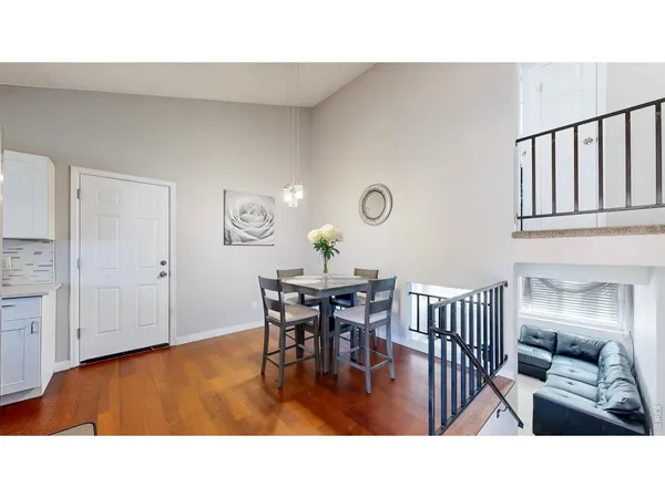 a living room with furniture a dining table and paintings on the wall