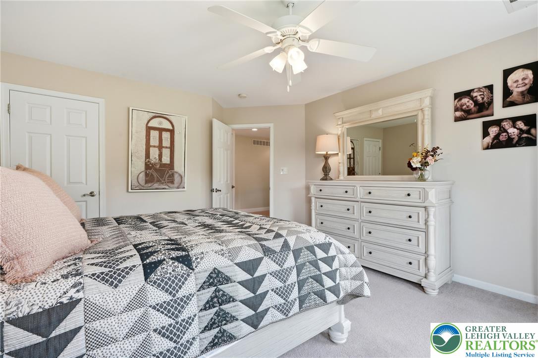 245 East Dell Road Bath, PA 18014 - Photo 44 of 99 A well-lit bedroom featuring a ceiling fan and a vanity with a large mirror.
