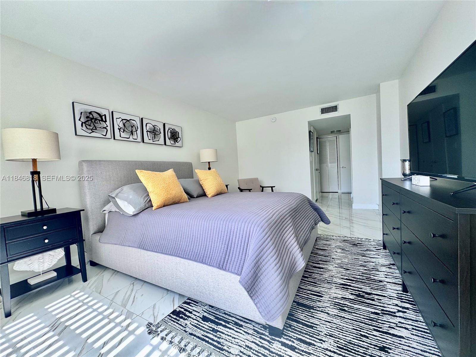 2851 Northeast 183rd Street, Unit 1508E Aventura, FL 33160 - Photo 11 of 27 a bedroom with bed and a night stand on dresser