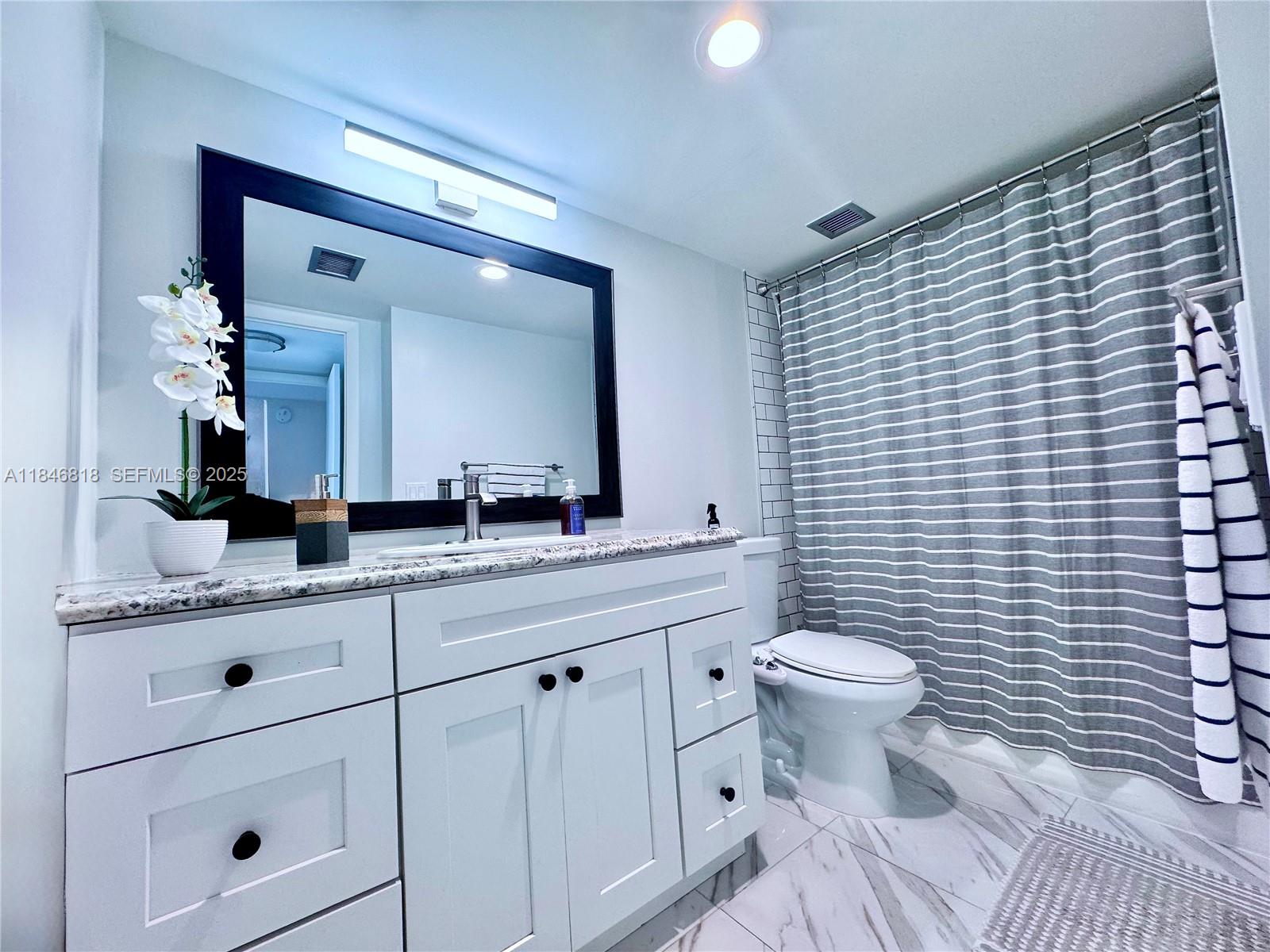 2851 Northeast 183rd Street, Unit 1508E Aventura, FL 33160 - Photo 12 of 27 a bathroom with a toilet a sink and mirror
