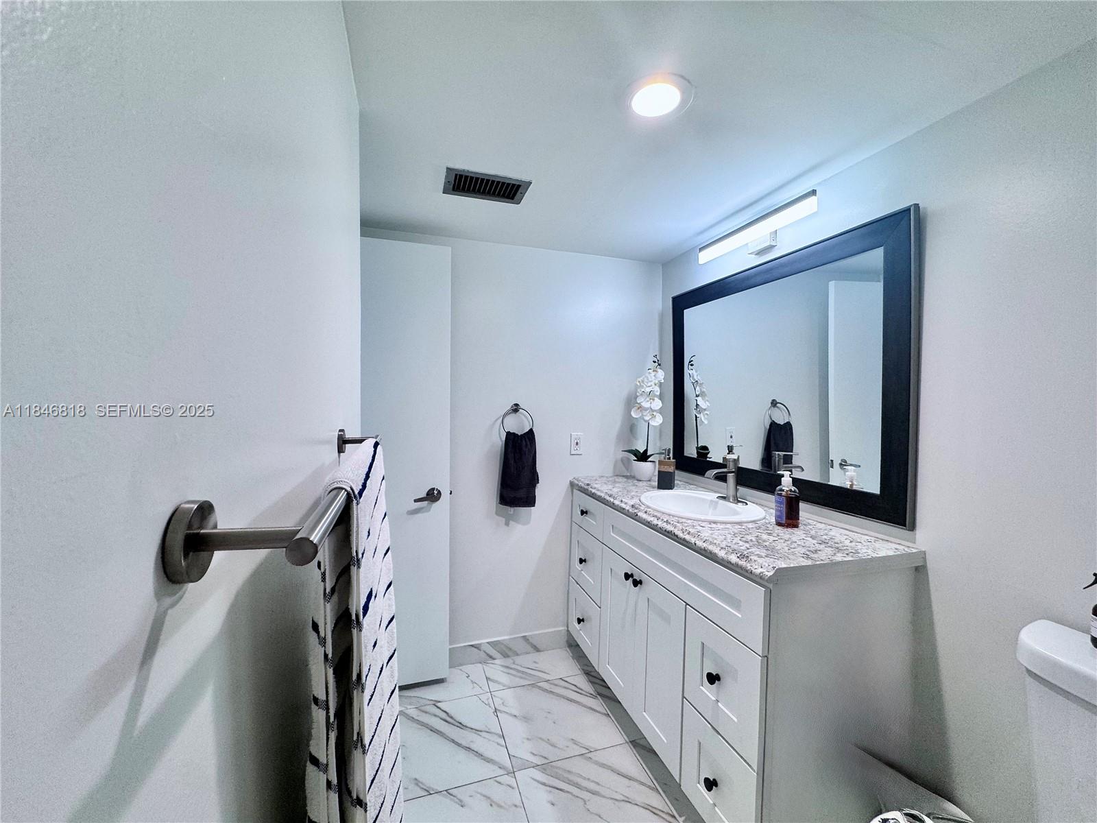 2851 Northeast 183rd Street, Unit 1508E Aventura, FL 33160 - Photo 13 of 27 a bathroom with a double vanity sink toilet and mirror