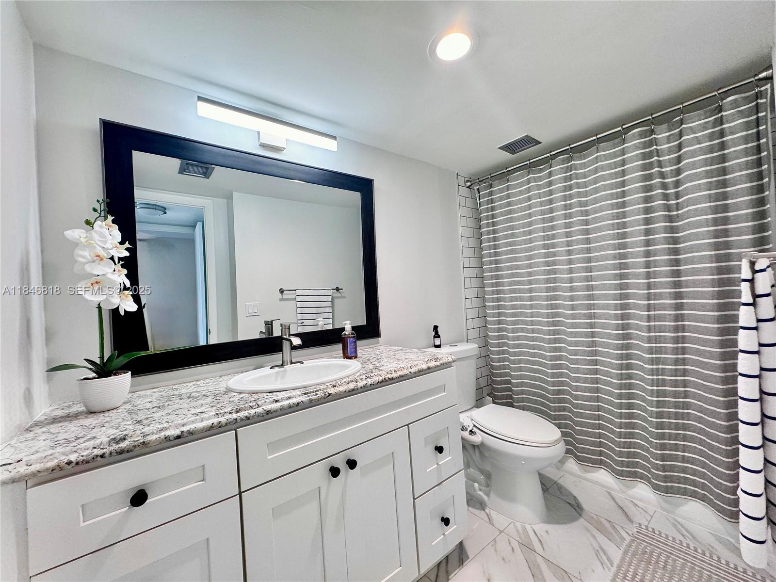 2851 Northeast 183rd Street, Unit 1508E Aventura, FL 33160 - Photo 14 of 27 a bathroom with a granite countertop toilet sink and mirror