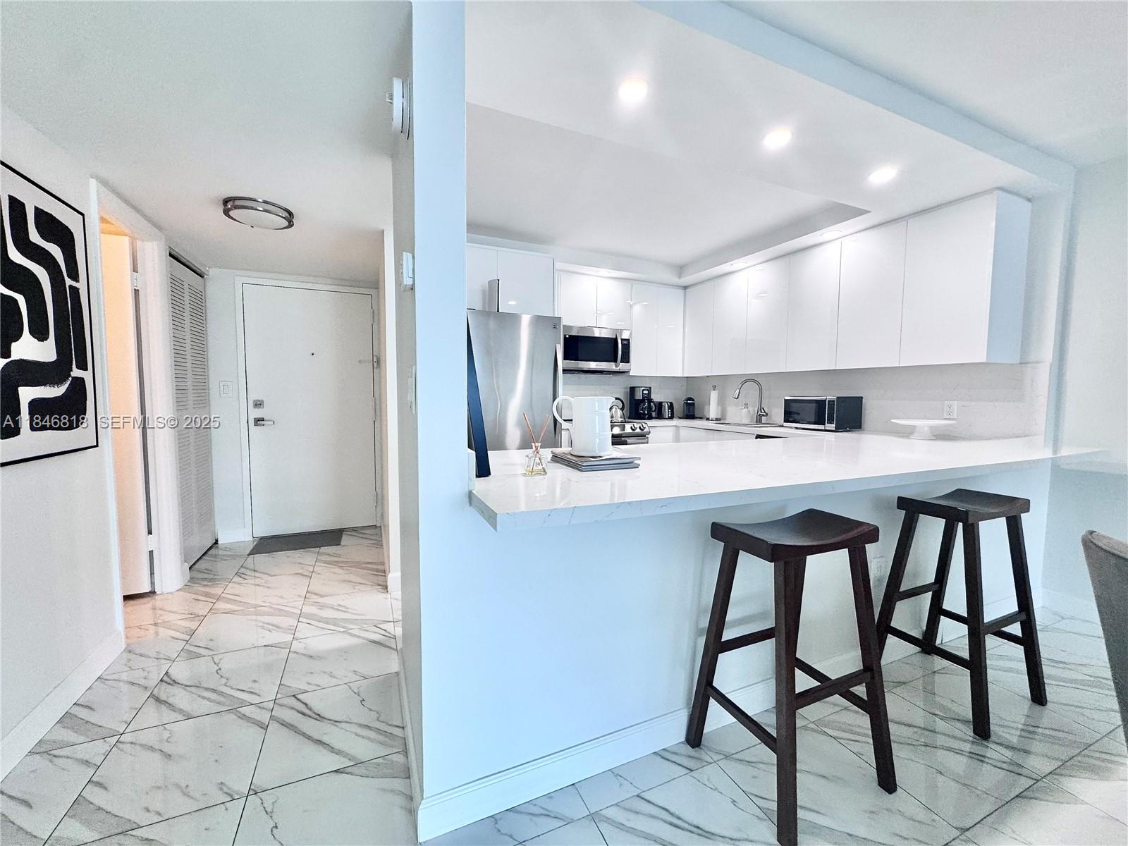 2851 Northeast 183rd Street, Unit 1508E Aventura, FL 33160 - Photo 4 of 27 a kitchen with stainless steel appliances a sink cabinets and a refrigerator