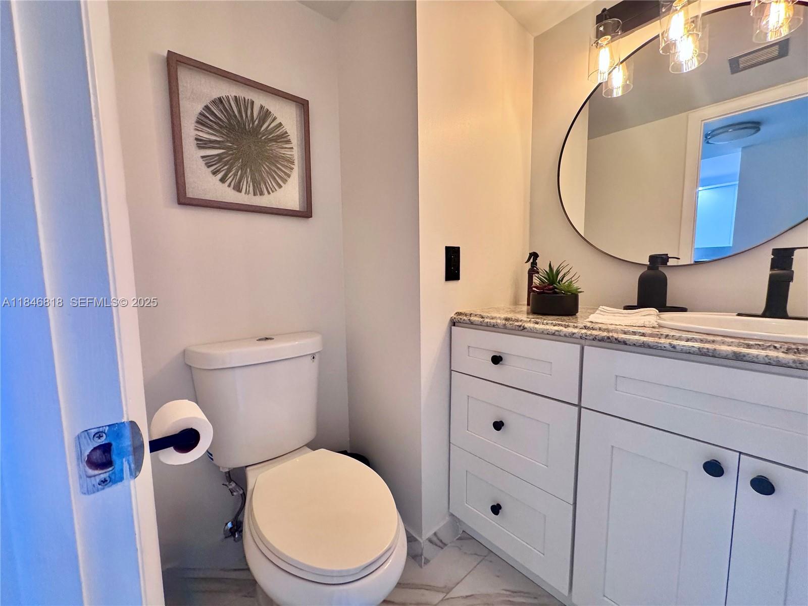 2851 Northeast 183rd Street, Unit 1508E Aventura, FL 33160 - Photo 5 of 27 a bathroom with a toilet a sink and a mirror