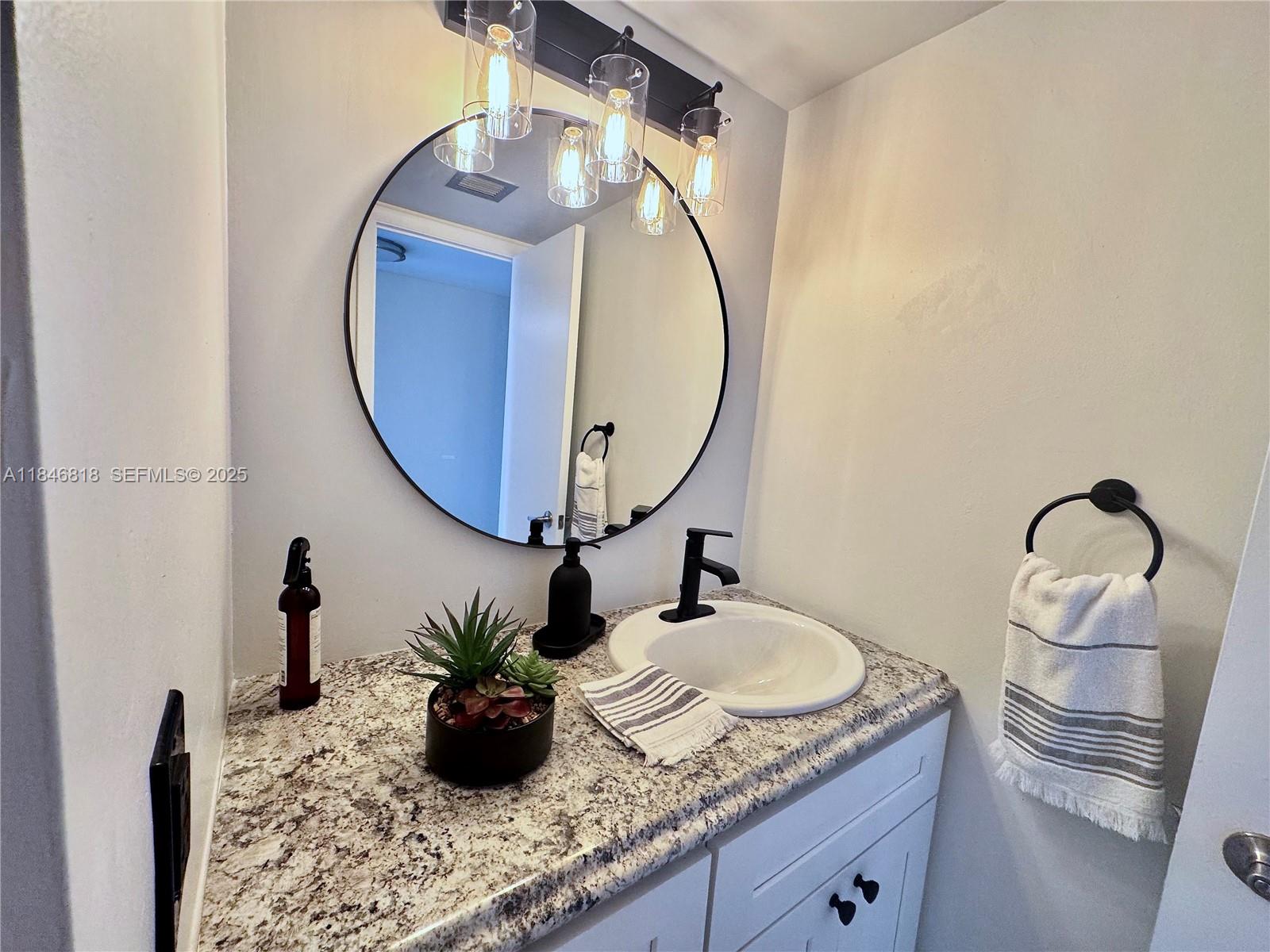 2851 Northeast 183rd Street, Unit 1508E Aventura, FL 33160 - Photo 6 of 27 a bathroom with a granite countertop sink mirror and vanity