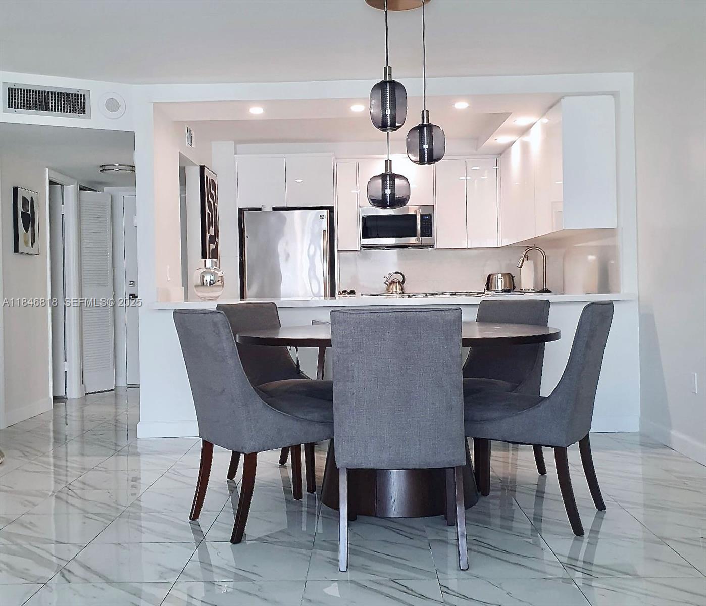 2851 Northeast 183rd Street, Unit 1508E Aventura, FL 33160 - Photo 7 of 27 a view of a dining room with furniture wooden floor and chandelier