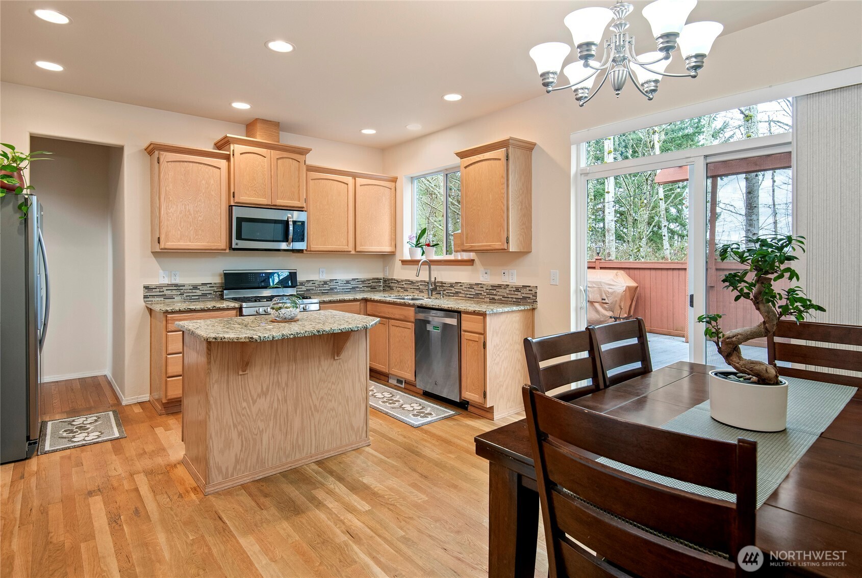 4023 160th Place Southeast Bothell, WA 98012 - Photo 6 of 22 a kitchen with kitchen island granite countertop stainless steel appliances a stove a sink a refrigerator cabinets and dining table