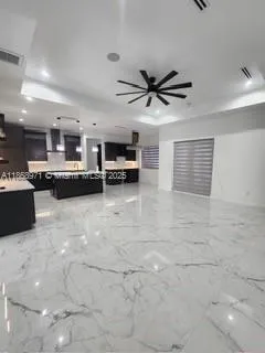 a kitchen with kitchen island a stove a counter space a sink and a cabinets