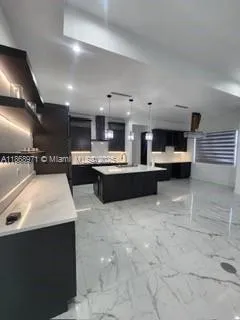 a view of a hallway with wooden floor and a kitchen