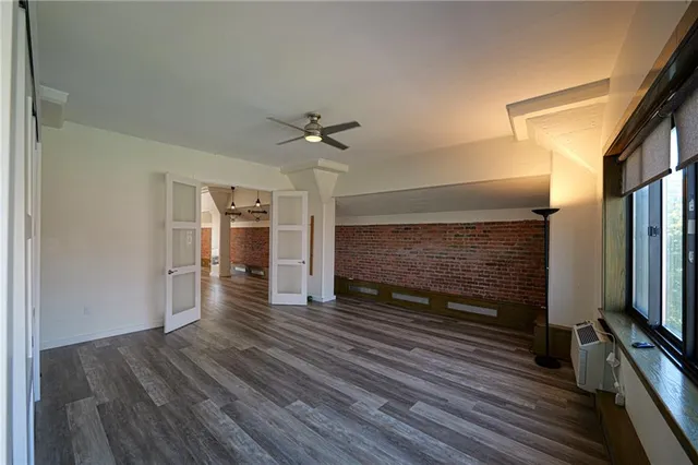 a view of a livingroom with wooden floor and a fireplace
