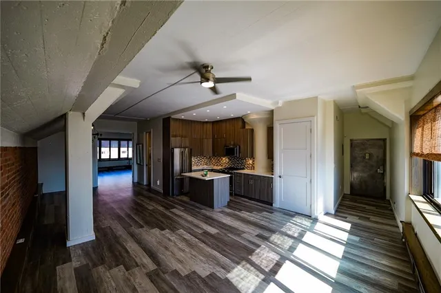 a view of a hallway with wooden floor and a ceiling fan