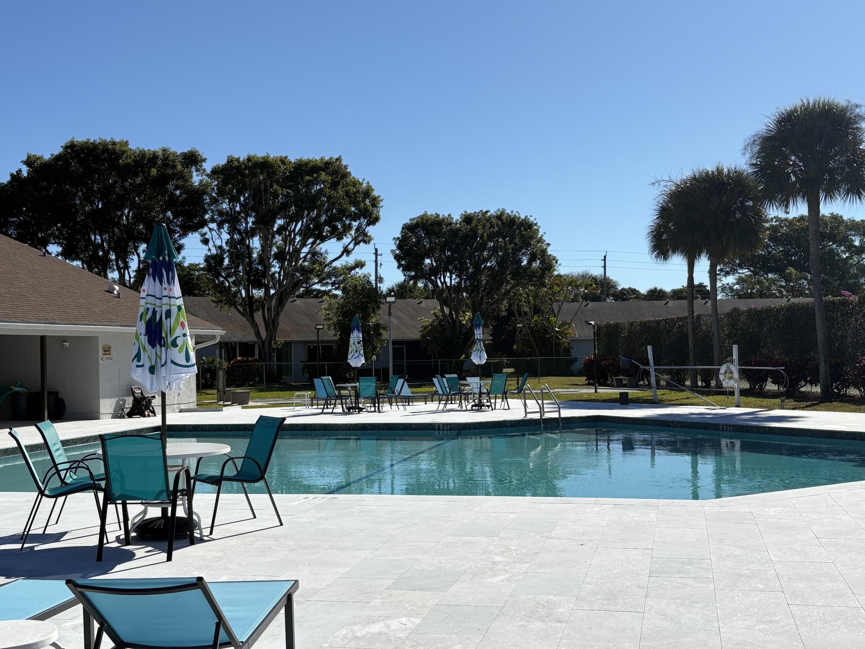2840 Casa Way, Unit 201 Delray Beach, FL 33445 - Photo 19 of 26 a swimming pool with outdoor seating and yard