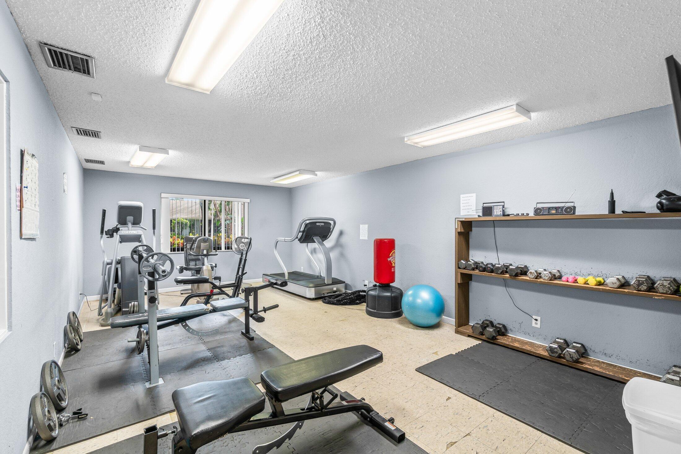 2840 Casa Way, Unit 201 Delray Beach, FL 33445 - Photo 25 of 26 a living room with furniture gym equipment and view of kitchen