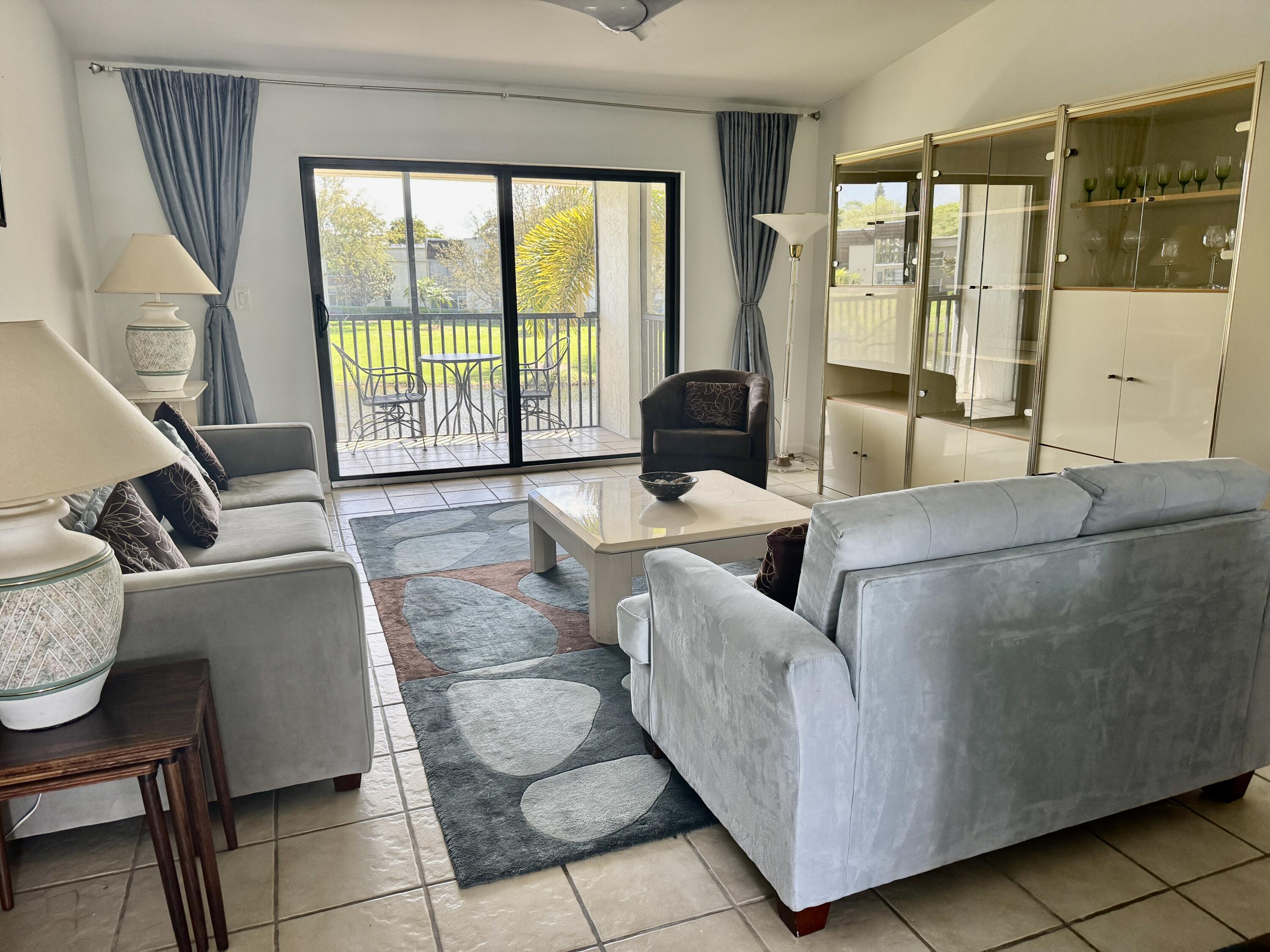 2840 Casa Way, Unit 201 Delray Beach, FL 33445 - Photo 6 of 26 a living room with couches and a large window