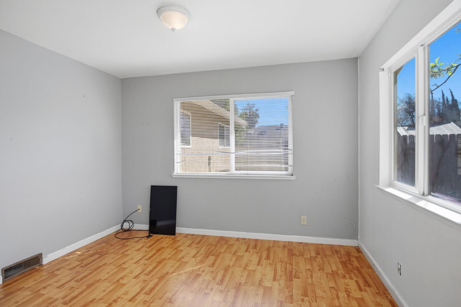 1409 Stonum Road Modesto, CA 95351 - Photo 11 of 40 a view of an empty room with wooden floor and a window