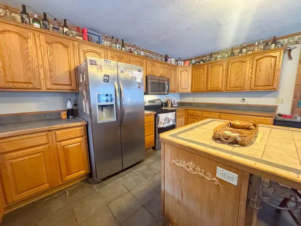 a kitchen with stainless steel appliances granite countertop a refrigerator stove and sink