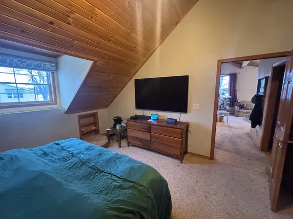 a bedroom with bed and flat screen tv