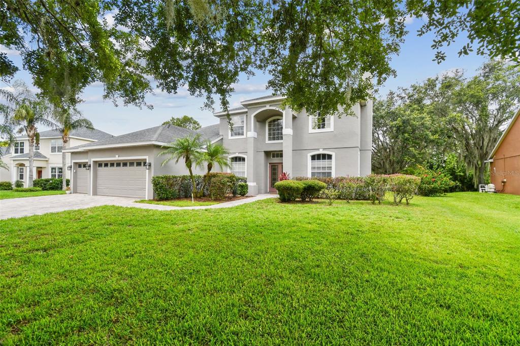 297 Beacon Pointe Drive Ocoee, FL 34761 - Photo 1 of 1 a front view of a house with a garden