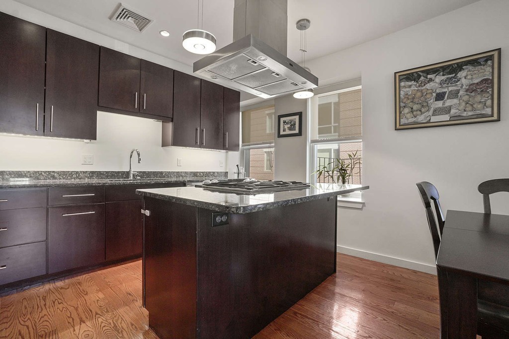 a kitchen with granite countertop a sink cabinets and wooden floor