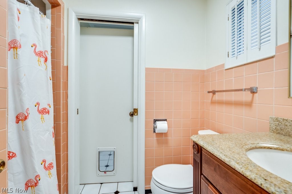 3060 Chamberlain Road Akron, OH 44333 - Photo 33 of 47 Bathroom with tile walls, toilet, tile floors, and vanity