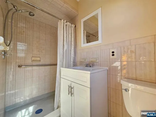 a bathroom with a sink vanity granite tub shower and mirror