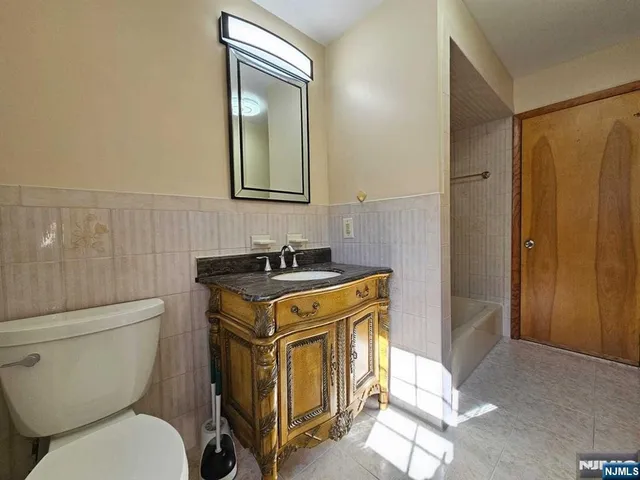 a bathroom with a granite countertop toilet sink and mirror
