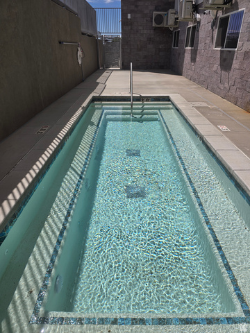 2085 North Main Street, Unit 306 Sunset, UT 84015 - Photo 5 of 18 Rectangular wading pool with tiled steps, a stainless steel handrail, and mosaic tile detailing