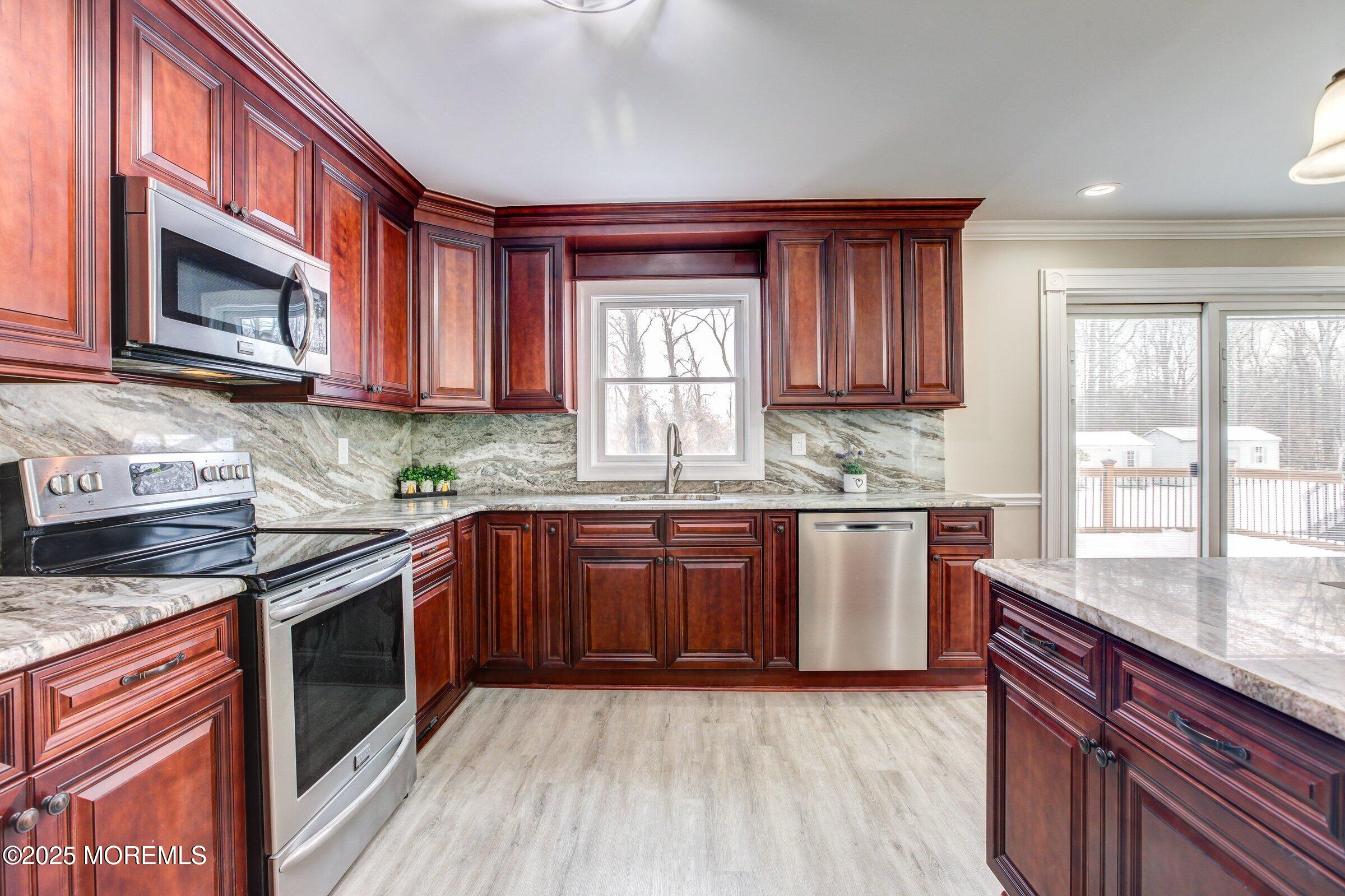 119 E Road Belford, NJ 07718 - Photo 7 of 21 a kitchen with stainless steel appliances granite countertop white cabinets granite counter tops and a window
