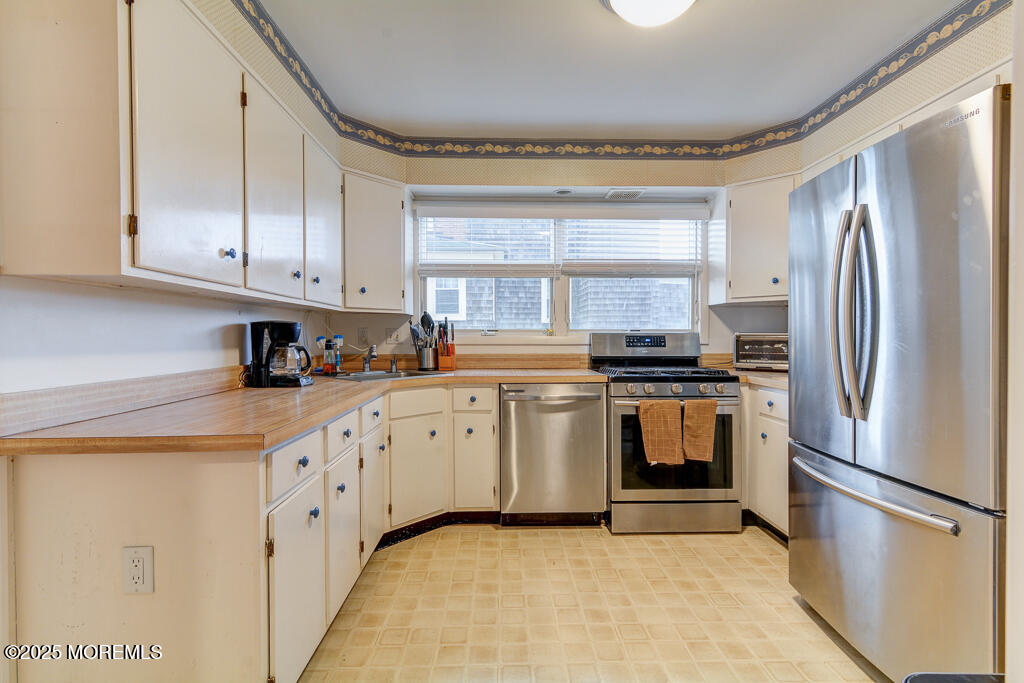 10 E Street Seaside Park, NJ 08752 - Photo 3 of 26 a kitchen with granite countertop white cabinets and stainless steel appliances