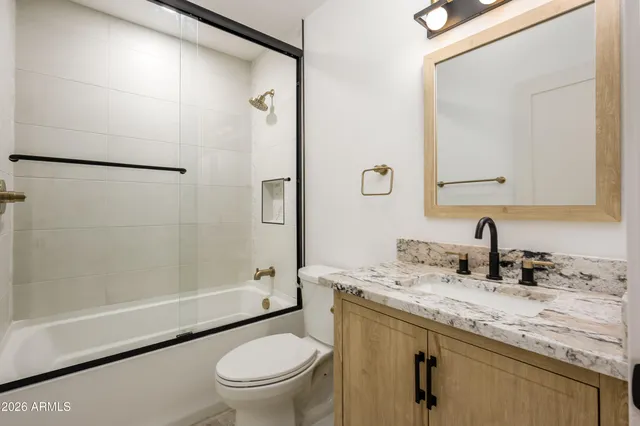 a bathroom with a granite countertop sink toilet and shower