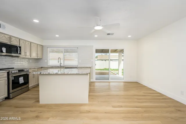 a kitchen with stainless steel appliances granite countertop a stove a sink and a microwave